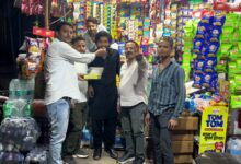 उमैर अली बैग तौहीद कुरैशी को मिठाई खिलाते हुए